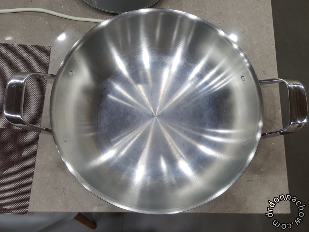 The stainless steel wok with rainbow stains on the bottom